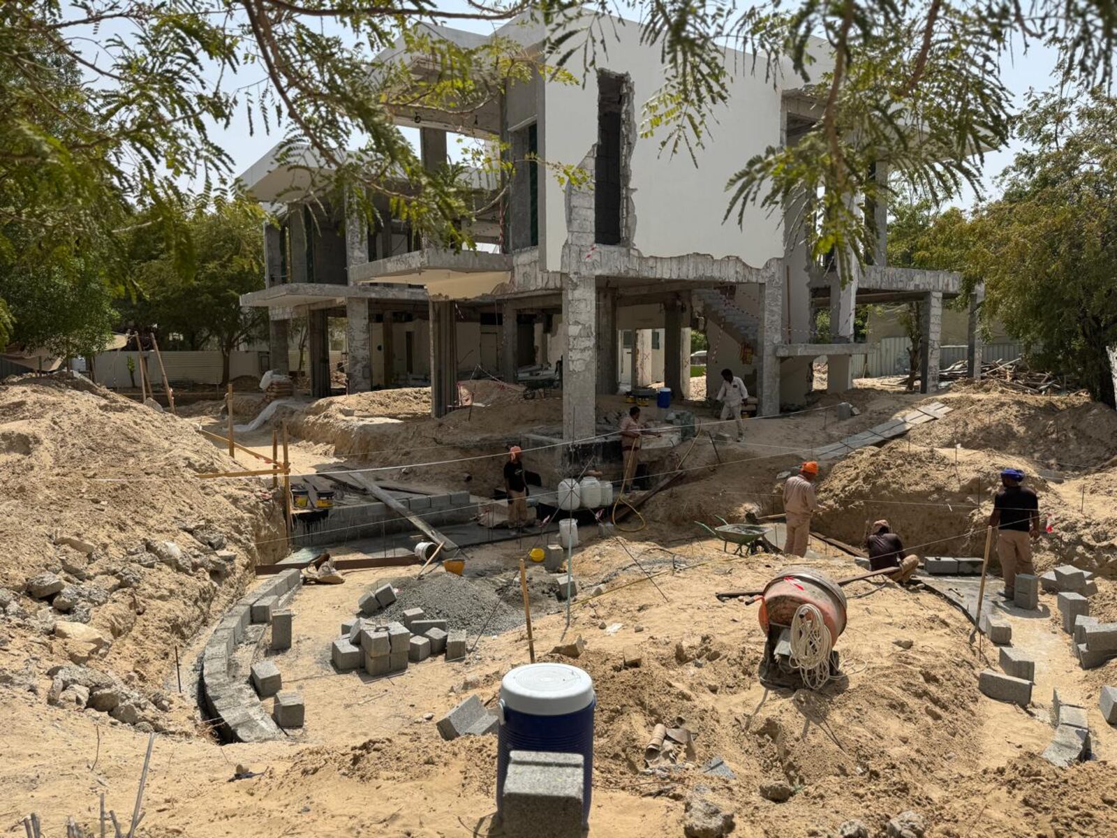 Nest A22 under construction in Al Barari, the reinforced structure standing among the trees, August 2026