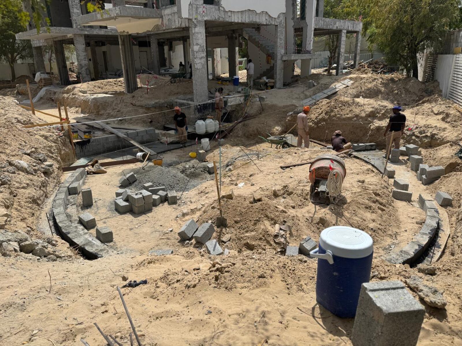 The free-form garden pool being set out at Nest A22, August 2026