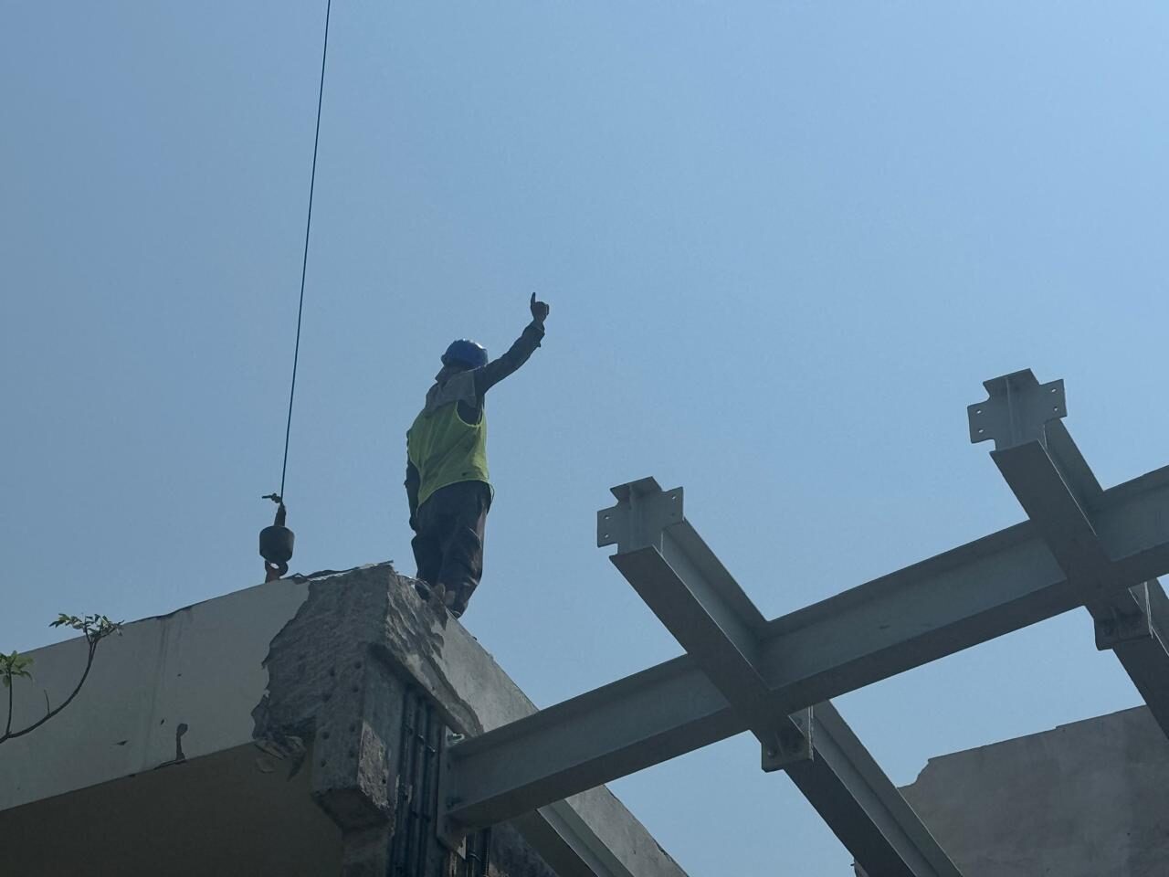A worker guiding a steel beam into place on top of Nest A22, September 2026